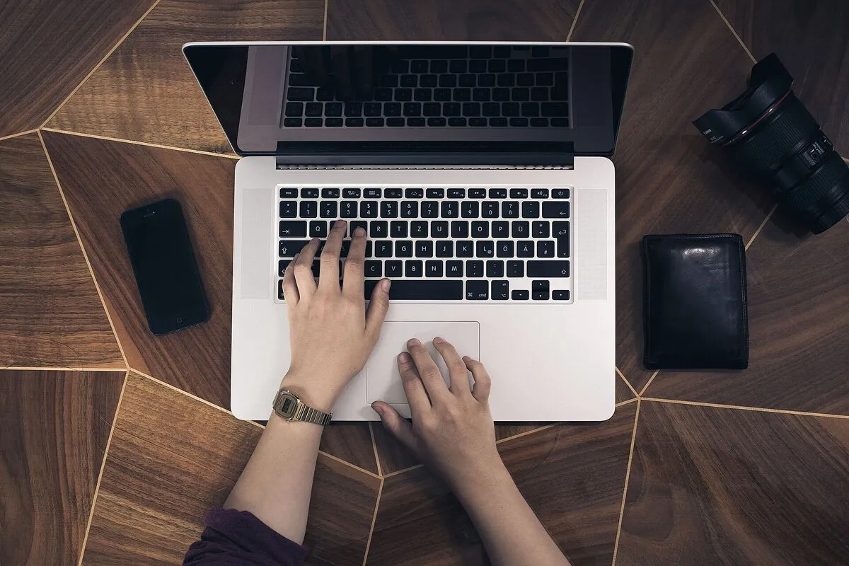 Mains sur le clavier d'un ordinateur portable